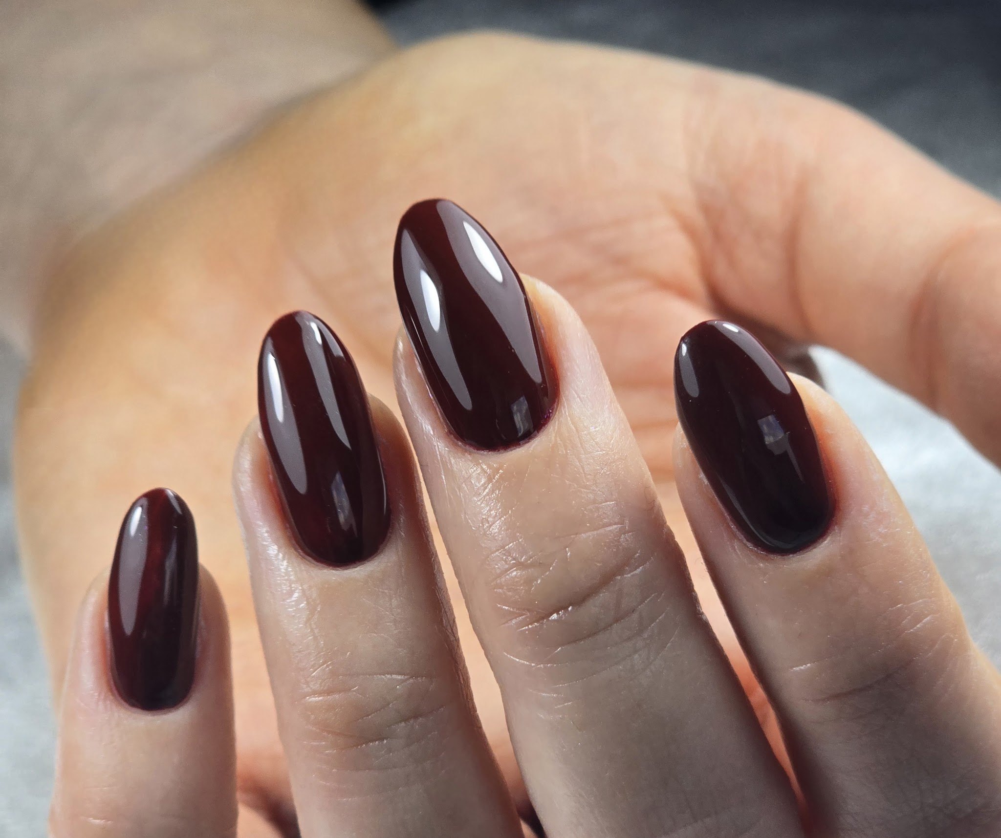 Donker bordeauxrode gellak op lange amandelvormige nagels